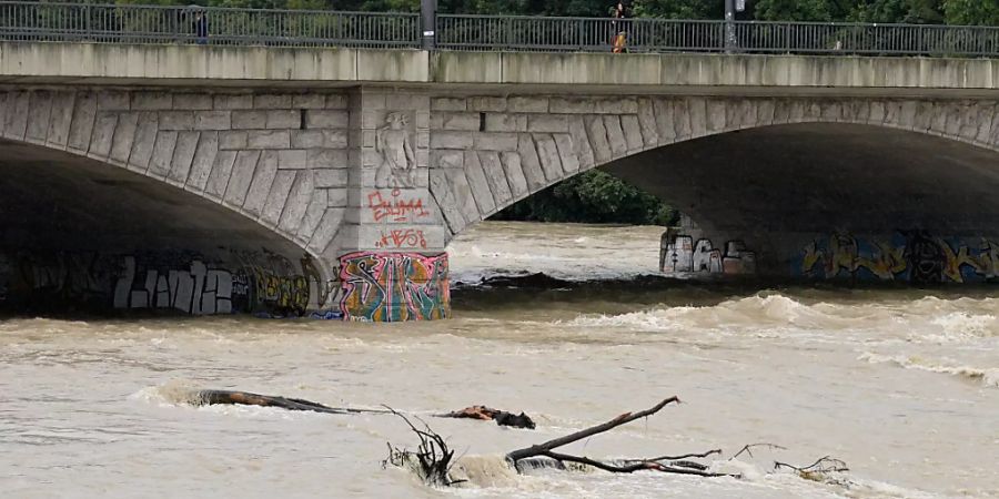 Braunes Wasser fliesst nach starken Regenfällen unter der Reichenbachbrücke durch das Flussbett der Isar in München. Foto: Peter Kneffel/dpa