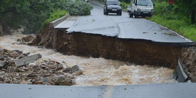 Dieses von der Feuerwehrzentrale Chungbuk bereitgestellte Foto zeigt Autos auf einer Strasse, die durch heftigen Regen eingebrochen ist. Hochwasser in Südkorea