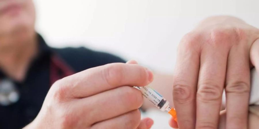 Ein Kinderarzt impft ein Kind mit einem 6-fach-Kombinationsimpfstoff gegen Diphtherie, Tetanus (Wundstarrkrampf), Kinderlähmung (Polio), Keuchhusten (Pertussis), Haemophilus influenzae Typ b (Hib) und Hepatitis B. Foto: Julian Stratenschulte/dpa