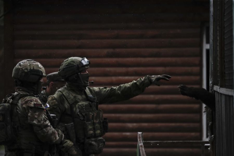 Ein Foto, das während eines vom russischen Militär organisierten Besuchs in Mariupol aufgenommen wurde, zeigt russische Soldaten vor einem Bärenkäfig in einem Zoo in Mariupol.