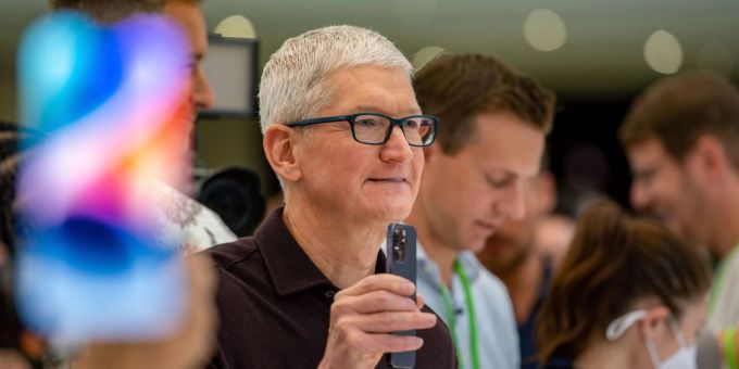 Apple-Chef Tim Cook mit einem iPhone 14 im September 2022. apple