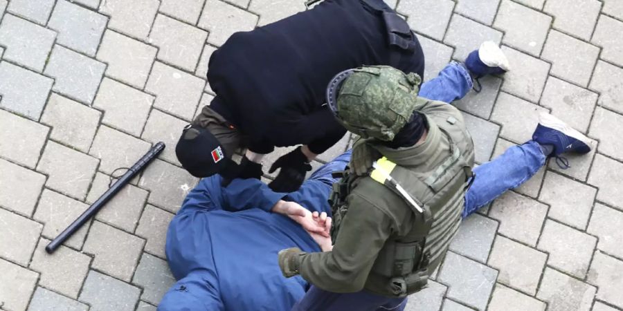 Polizisten nehmen während eines Protests der Opposition in Minsk einen am Boden liegenden Mann fest. Foto: ---/AP/dpa