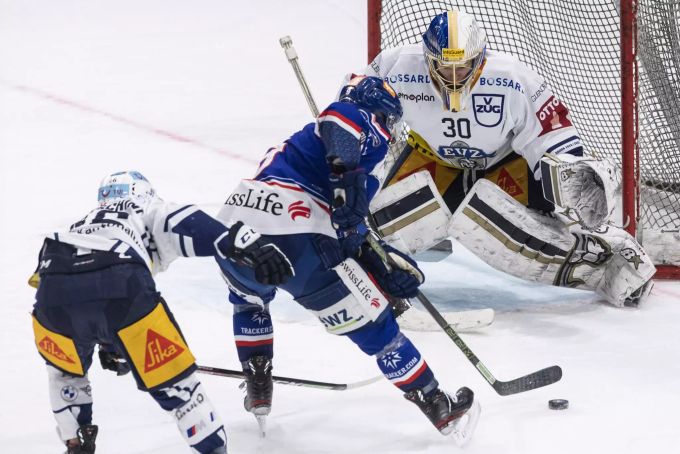 Garrett Roe von den ZSC Lions taucht vor Zug-Goalie Leonardo Genoni auf. ZSC
