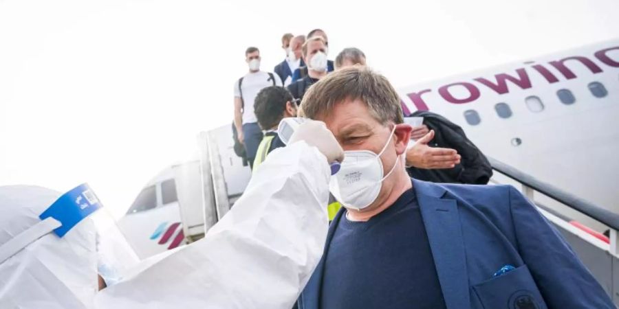 Fiebermessen zur Begrüssung: Alfred Gislason ist mit den deutschen Handballern in Ägypten angekommen. Foto: Sascha Klahn/dpa