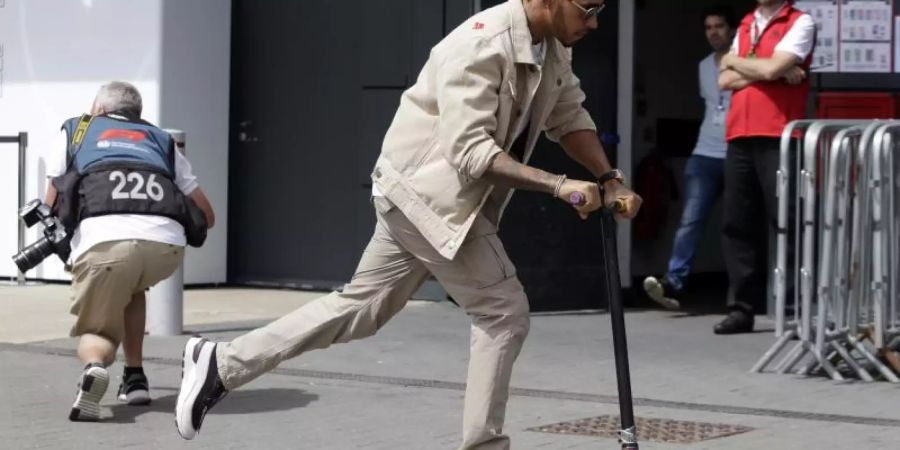 Läuft sich auf der Rennstrecke von Silverstone mit einem Roller warm: WM-Spitzenreiter Lewis Hamilton. Foto: Luca Bruno/AP
