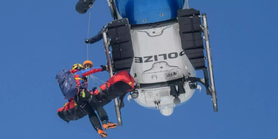 Helfer der Bergwacht an einem Polizeihubschrauber