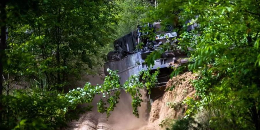 Ein Panzer der Bundeswehr räumt eine Brandschneise. Mit den Schneisen soll eine weitere Ausbreitung des Feuers verhindert werden. Foto: Jens Büttner