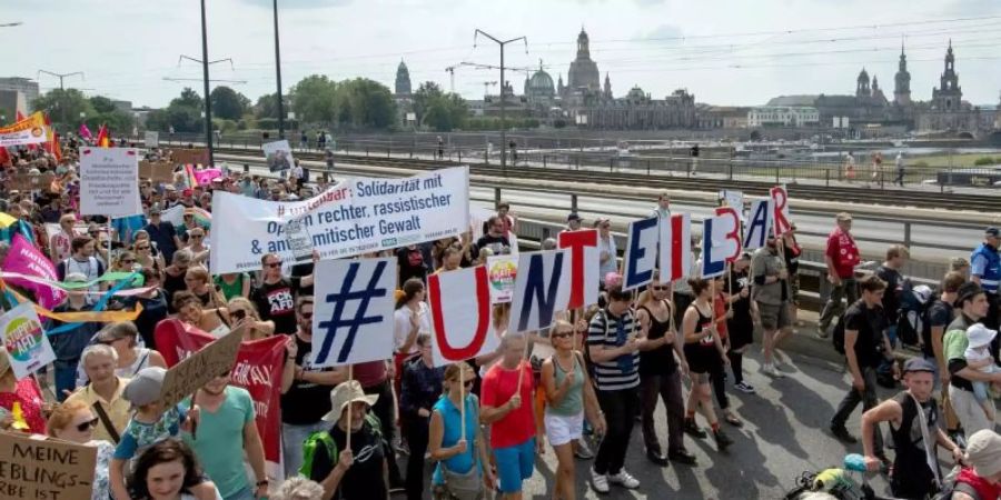 Vor der historischen Altstadtkulisse gehen Tausende Teilnehmer der Demonstration des Bündnisses #Unteilbar über die Carolabrücke in Dresden. Foto: Robert Michael