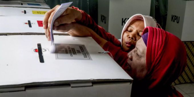 Eine blinde Frau wählt in Indonesien. blind e-voting