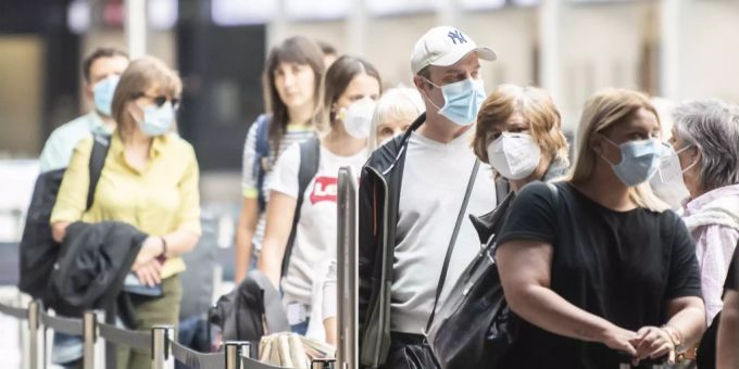 Fluggäste warten mit Atemschutzmasken vor einem Check-In Schalter aufgenommen anlässlich des Schutzkonzeptes vom Flughafen Zürich, aufgenommen am Donnerstag, 28. Mai 2020 in Zürich. Reisende Coronavirus