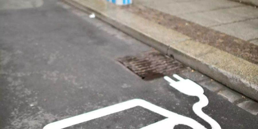 Ein Elektrofahrzeug kennzeichnet einen Parkplatz neben einer Ladesäule an einer Strasse. Foto: Jan Woitas/dpa-Zentralbild/dpa