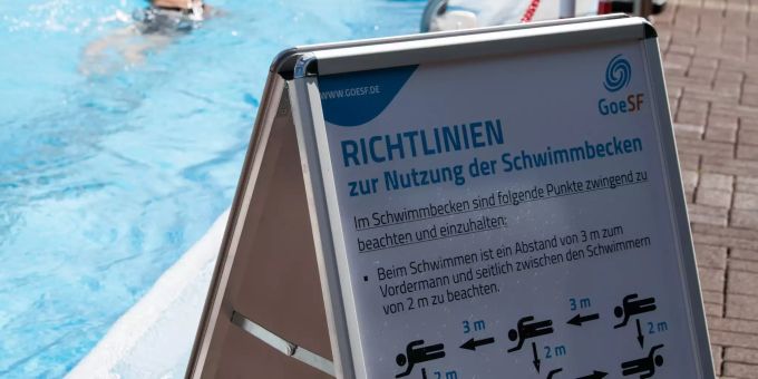 Ein Schild mit Richtlinien zur Nutzung der Schwimmbecken steht vor dem 50-Meter-Becken im Freibad Brauweg. Nach der Lockerung der Massnahmen zur Eindämmung des Coronavirus startet das Freibad unter Beachtung der noch geltenden Beschränkungen in die Saison. Eröffnung von Freibädern in Niedersachsen
