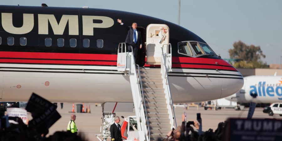 Donald Trump steigt aus Flugzeug aus.