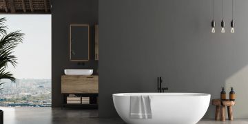 Graues Badezimmer mit weisser Wanne und Holzelementen