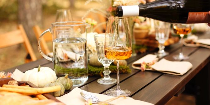 Tisch gedeckt Weinglas Weinflasche Befüllung Orangenwein