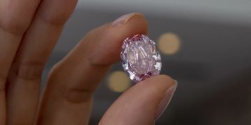 Frau hält rosa Diamanten