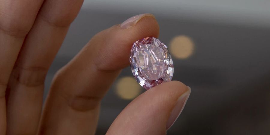 Frau hält rosa Diamanten