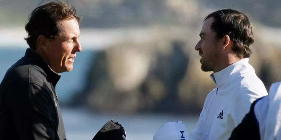 Phil Mickelson (l) gratuliert Nick Taylor zum Sieg beim PGA-Turnier in Pebble Beach. Foto: Eric Risberg/AP/dpa