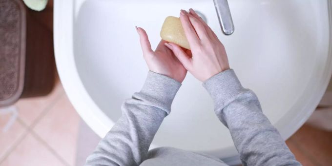 Eine Frau wäscht sich die Hände. Erkältung Frau Händewaschen Waschbecken