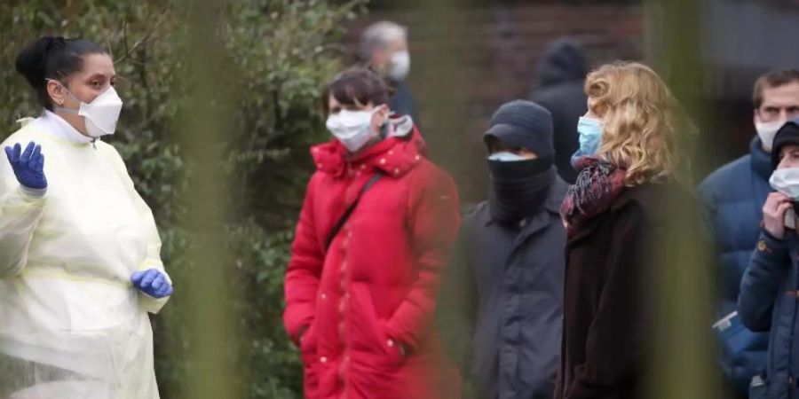 Eine Mitarbeiterin des Wenckebach-Klinikums im Bezirk Tempelhof informiert Menschen über die Vorgehensweise in der Abklärungsstelle Coronavirus. Foto: Wolfgang Kumm/dpa