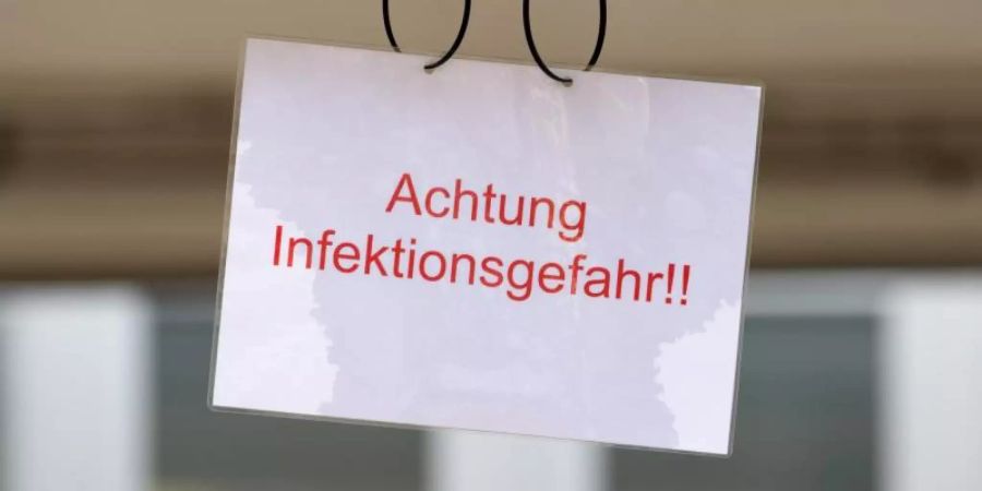 Ein Schild mit der Aufschrift «Achtung Infektionsgefahr!» an einem Johanniter-Zelt in Brandenburg. Foto: Soeren Stache/dpa-Zentralbild/dpa