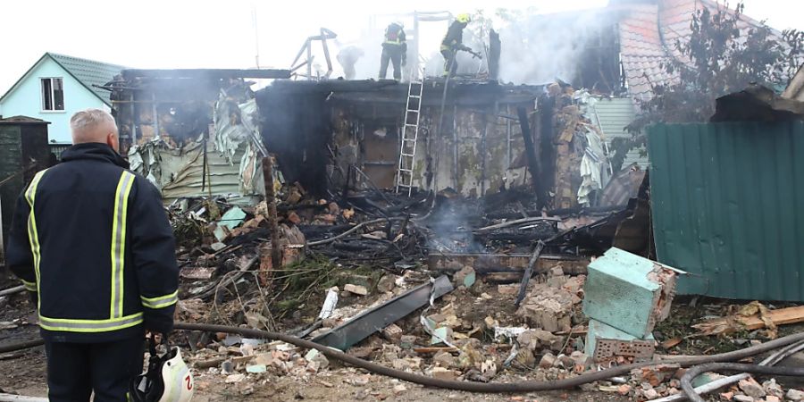 Feuerwehrleute löschen ein Feuer nach einem Raketenangriff nahe Kiew. Foto: ---/Ukrinform/dpa