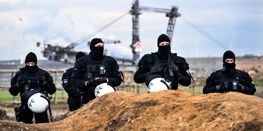 Polizisten sichern das Gelände beim Braunkohletagebau Garzweiler II.