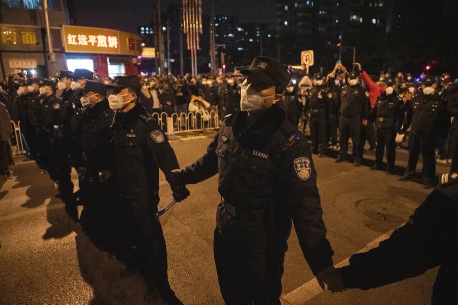 Polizeibeamte halten Demonstrierende in Schach in Peking, 27. November 2022.