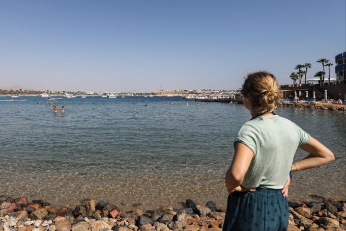 Die Lage am Roten Meer lockt viele Touristen nach Scharm el Scheich. Rotes Meer transparent Wasser Frau Steine Ufer