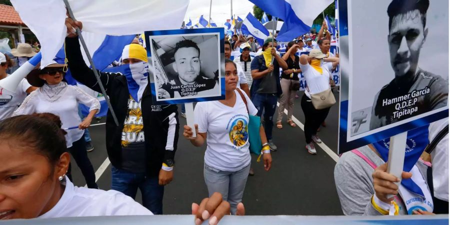 Demonstranten in Managua zeigen Fotos von Menschen, die in den vergangenen Monaten bei gewalttätigen Auseinandersetzungen mit der Polizei getötet worden sind, bei einem Protestmarsch, der die katholische Kirche unterstützt.