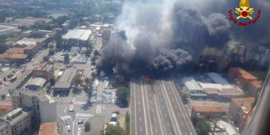 Diese von der italienischen Feuerwehr zur Verfügung gestellte Luftaufnahme zeigt Feuer und dichte Rauchwolken nachdem auf der Autobahn nahe des Flughafens ein Tanklaster explodiert ist.