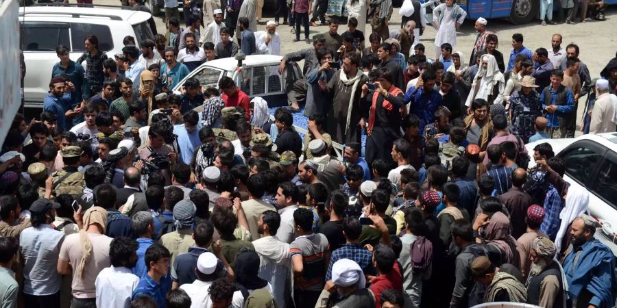 Viele Passagiere warten an einer Bushaltestelle auf einen Bus, der sie aus der Stadt in Afghanistan bringen kann. (Symbolbild)