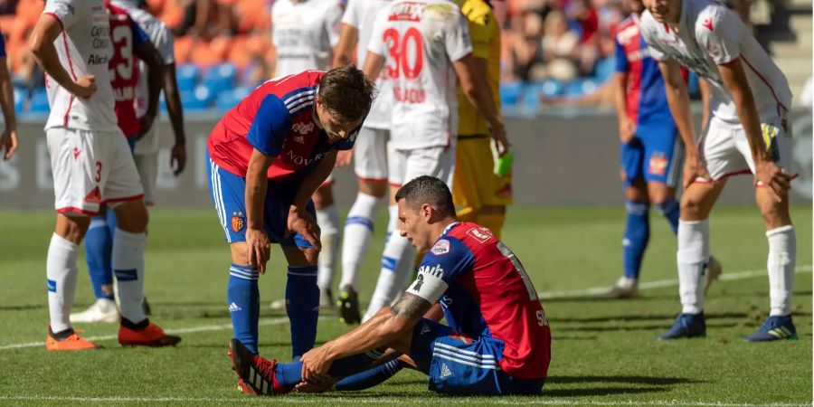 Marek Suchy (m.) sitzt verletzt am Boden im Fussball Meisterschaftsspiel der Super League zwischen dem FC Basel 1893 und dem FC Sion.