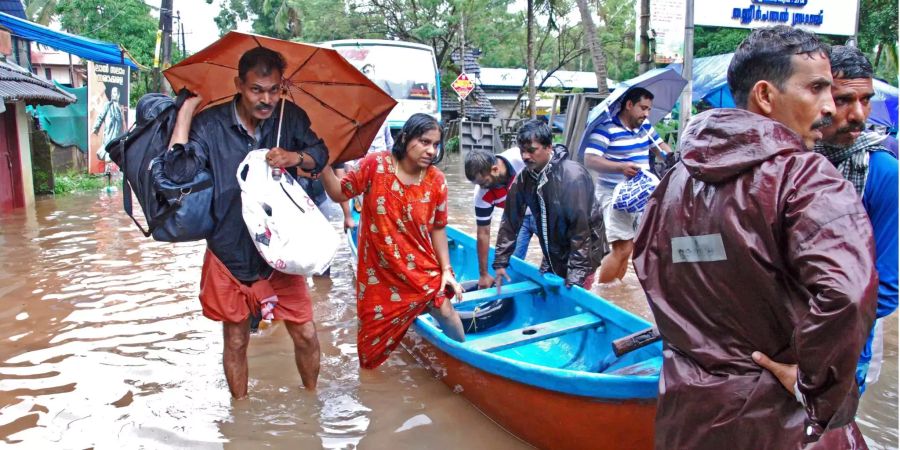 Flutopfer werden im südindischen Kozhikode (IND) von Helfern evakuiert.