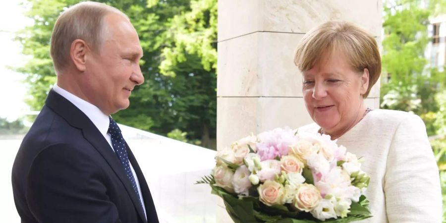 Kanzlerin Merkel trifft Präsident Putin in Sotschi: Wladimir Putin (l.), Präsident von Russland, überreicht Bundeskanzlerin Angela Merkel (CDU) zur Begrüssung einen Blumenstrauss.