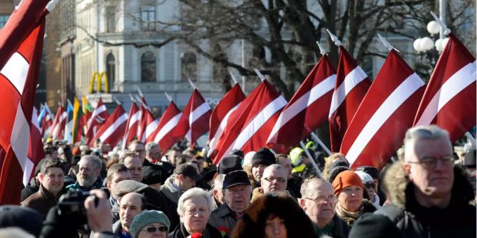 Menschen tragen die lettische Staatsflagge während eines Marsches zum Gedenken an Waffen-SS-Veteranen in Riga. Menschen tragen die lettische Staatsflagge während eines Marsches zum Gedenken an Waffen-SS-Veteranen in Riga.