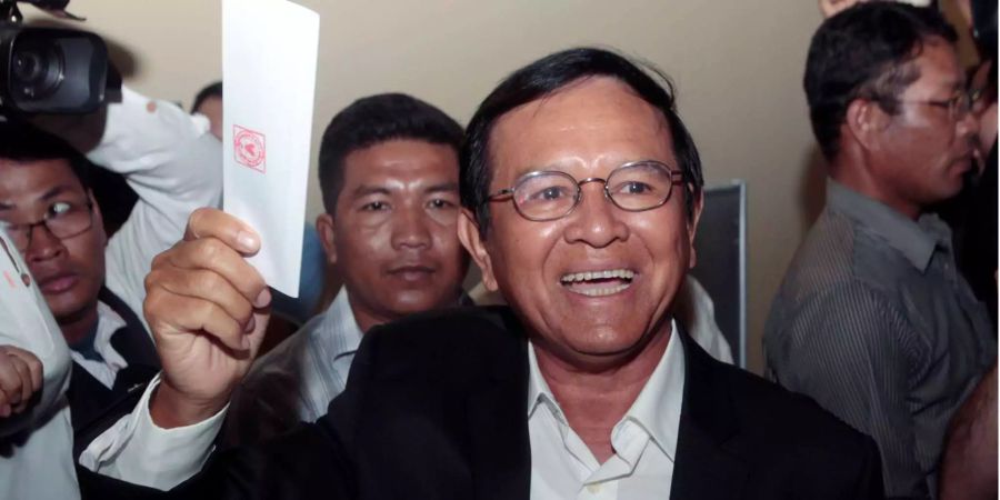 Kem Sokha, Präsident der kambodschanischen Nationalen Rettungspartei (CNRP) zeigt seine Stimmkarte bevor er in Chak Angre Leu (KHM) seine Stimme abgibt.