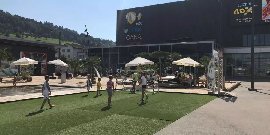 Die Mall of Switzerland besitzt ein eigenes Kino, Fitness-Center, oder auch ein Fussballfeld vor dem Einkaufs-Tempel.