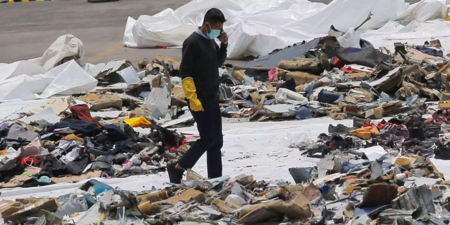 Ein Ermittler geht inmitten von Trümmern des kurz nach dem Start ins Meer gestürzten Passagierflugzeug der Fluggesellschaft Lion Air.