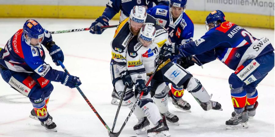 Jiri Novotny und Fabio Hofer kämpfen mit vereinten Kräften gegen vier ZSC-Spieler um den Puck.