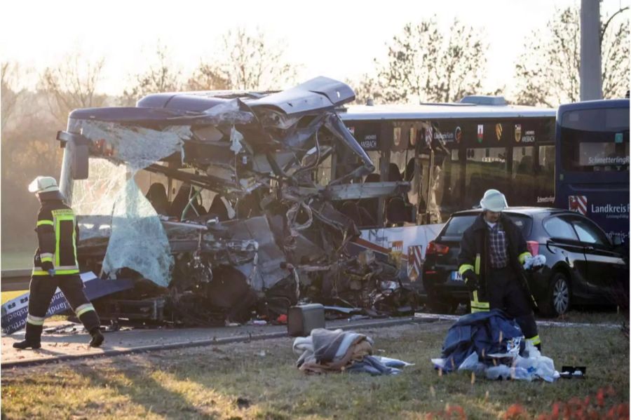 Helfer räumen die Teile des Unfallbusses weg.