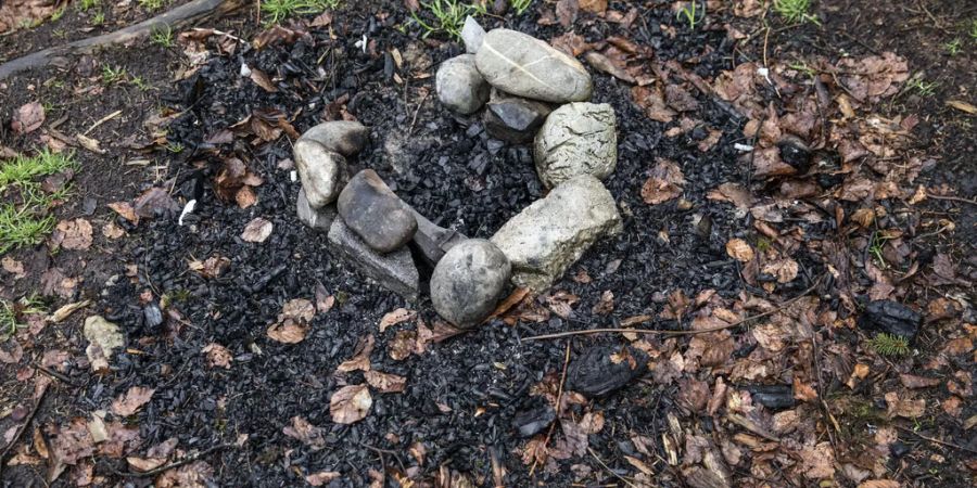 Ausgebrannte Feuerstelle im Wald. - Keystone