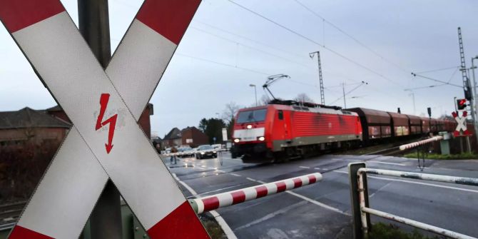 Ein Güterzug fährt über eine Bahnkreuzung.