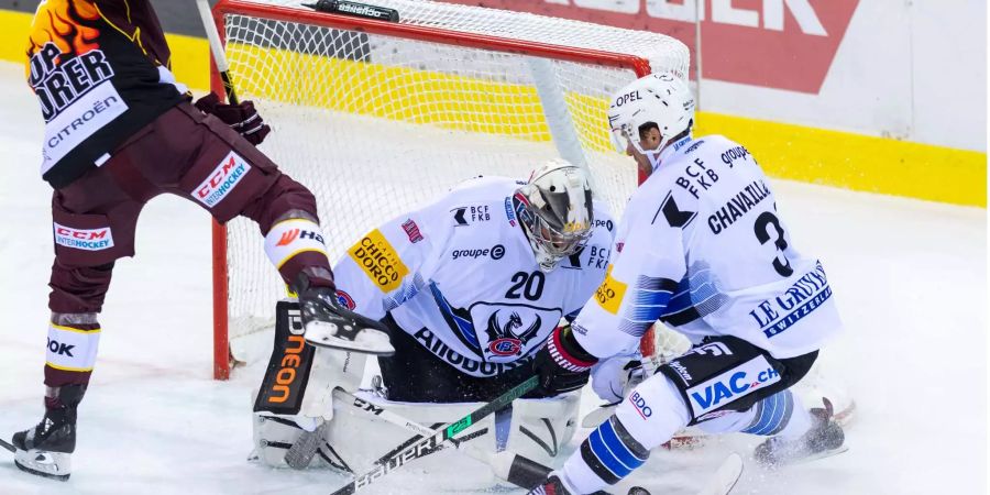 Die Freiburger Benjamin Chavaillaz (rechts) und Reto Berra (Mitte) gegen den Genfer Noah Rod.