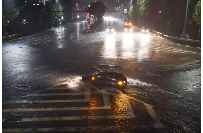 Ein Fahrzeug fährt über eine durch Taifun «Lan» überflutete Strasse in Nagoya (Japan). Ein Fahrzeug fährt über eine durch Taifun «Lan» überflutete Strasse in Nagoya (Japan).