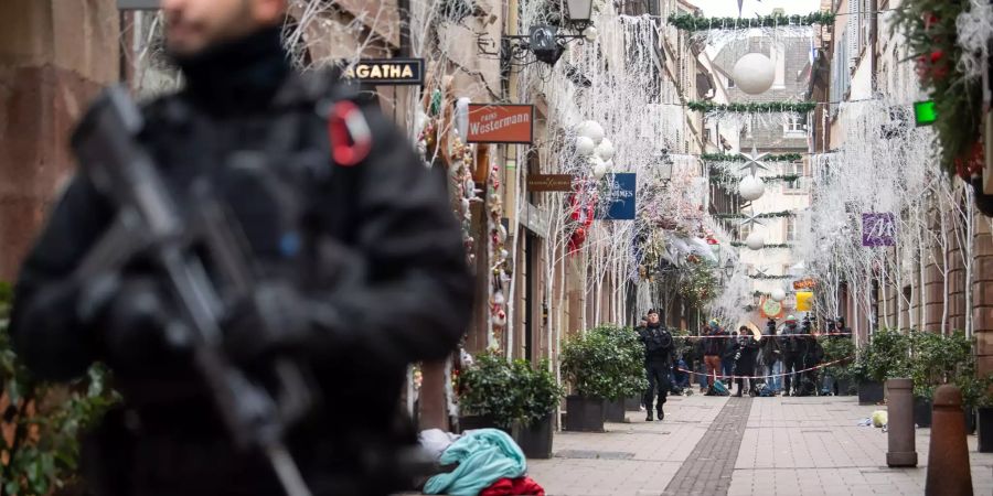 Ein Polizist steht nach einem Angriff in der Gegend des Strassburger Weihnachtsmarkts vor einem Tatort.