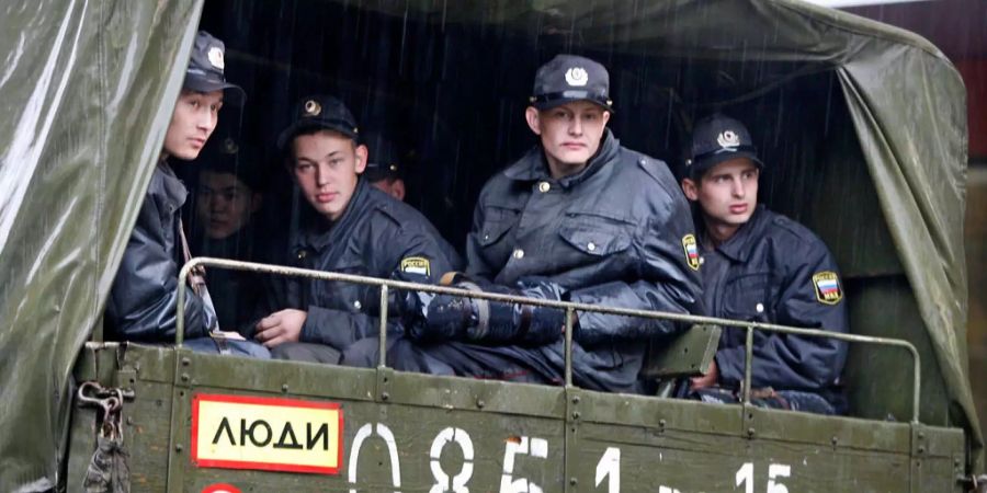 Polizisten sitzen in Russland in einem Lastwagen.