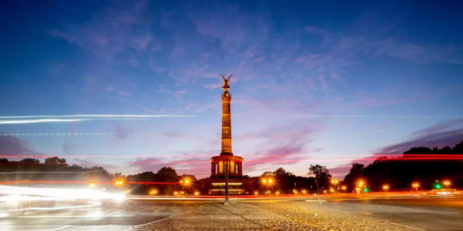 Der Auto- und Fahrradverkehr zeigt sich als Leuchtspuren vor der Berliner Siegessäule.