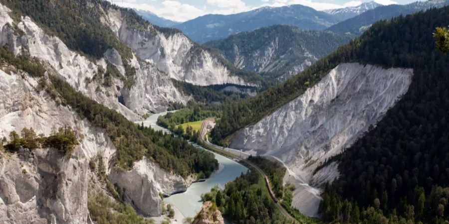 Ein Zug der Rhätischen Bahn fährt durch die Rheinschlucht bei Versam in Graubünden.