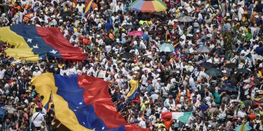 Demonstranten tragen Nationalflaggen während eines Protestes gegen Nicolás Maduro in Caracas. Foto: Roman Camacho